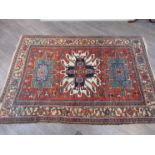 A wool rug with three central lozenges, multiple borders and tasselled ends,