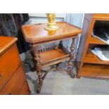 A Victorian walnut two tier lamp table on turned and reeded supports with turned spindle gallery