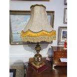 An ornate table lamp with silk tasselled shade ormolu column to marble base.