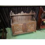A carved wall hanging, two door cupboard with upper shelf,