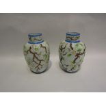 A pair of early 20th Century opaque glass vases with hand-painted tree blossom design,