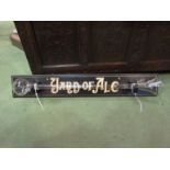 A glass yard of ale mounted on wooden board