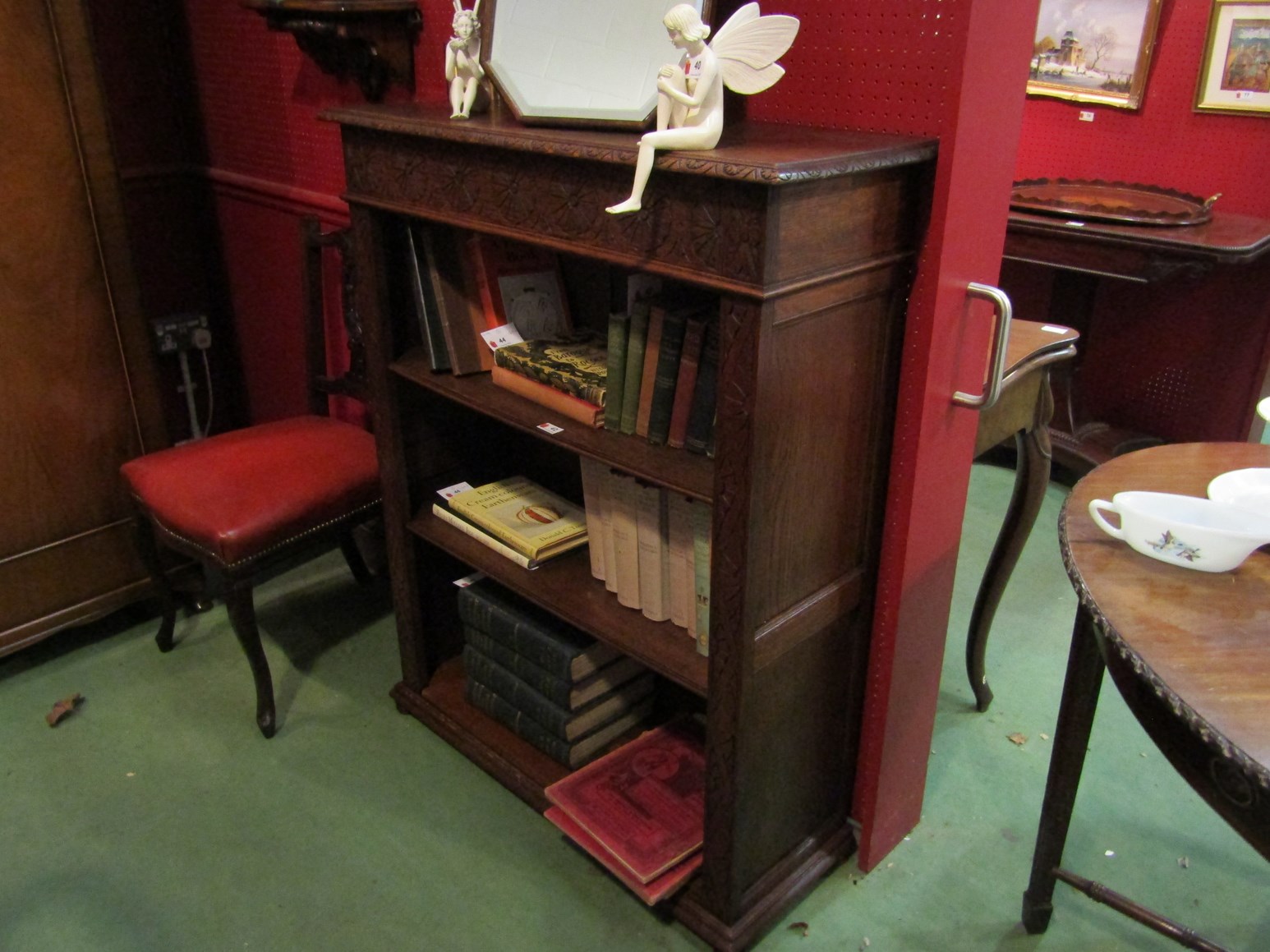 A circa 1900 oak freestanding bookshelf with height adjustable shelves and carved decoration,