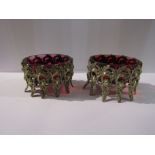 A pair of Victorian cranberry glass salts in silver stands