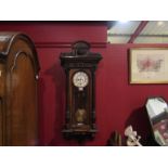 A Vienna wall clock with pendulum and two weights,