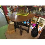 An 18th Century style oak oval top gateleg occasional table the rising leaves over turned legs,