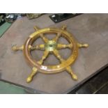 A wooden and brass ships wheel,