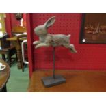 A carved wooden rabbit on stand,