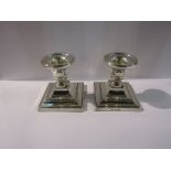 A pair of W I Broadway & Co filled silver squat form candlesticks, marked Birmingham,