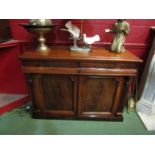 A 19th Century flame mahogany sideboard with twin cushion drawers over two cupboard doors to plinth