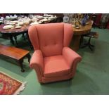 A pair of early 20th Century wingback armchairs in salmon button upholstery