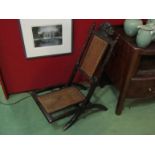 A 19th Century folding chair with carved backrest having a carved coronet & Prince of Wales