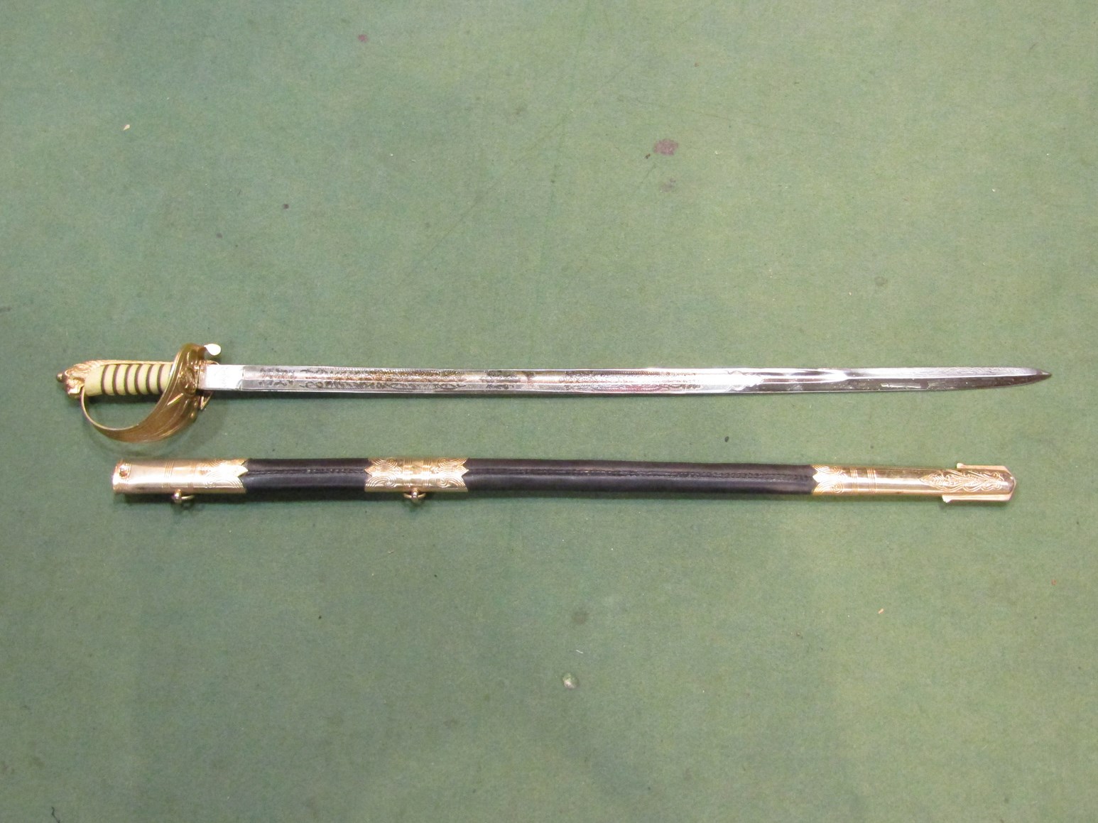 A reproduction Naval officer's sword with sheath for decorative use