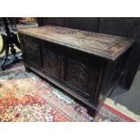 A Victorian carved oak coffer with three carved panels,