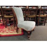 An early Victorian walnut nursery open armchair with carved acanthus leaf scroll back rest over