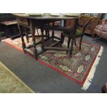 A red ground rug, central square medallion, mulitple borders,