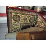 A red and cream ground rug with multiple borders,