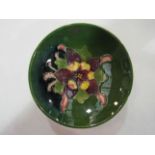 A Moorcroft dish with floral design on green ground,