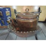 A copper lidded pot and scoop