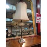 A silver plated column form table lamp with glass reservoir design and shade