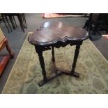 An Edwardian oak clover leaf top lamp table on turned and carved tri-legs with sledge feet base,