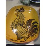 A British studio pottery slipware dish by David Eeles of cockerel design