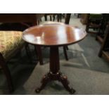 An early Victorian walnut wine table the dished circular top on fluted column and carved scroll