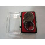 A cased 30x metallic jeweller's loupe