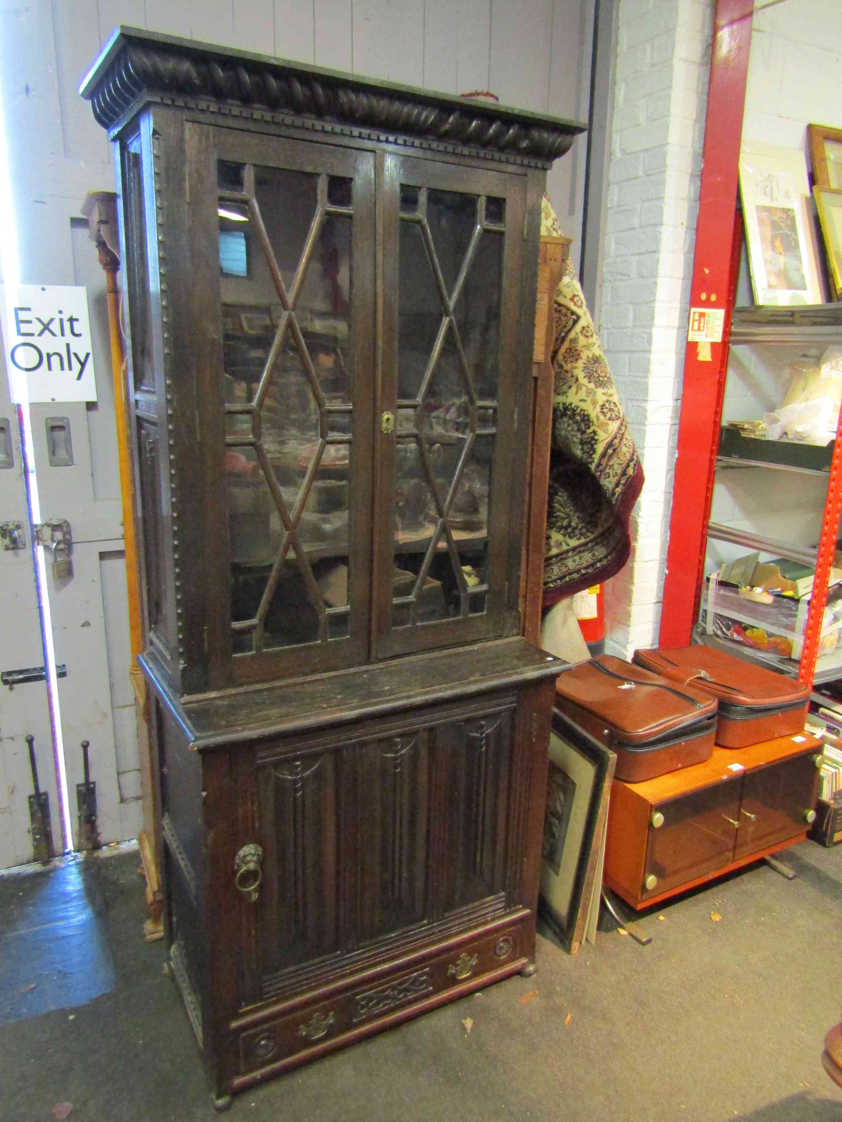 A heavily carved oak bookcase with astragal glazed doors,