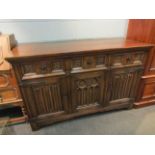 A Titchmarsh & Goodwin 18th Century style carved oak dresser base with Gothic tracery and linen