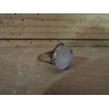 A yellow metal moonstone ring