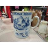 An Oriental blue and white tankard, staple repaired,