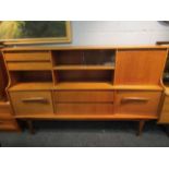A 1960's/70's teak sideboard, central glazed section, multiple drawers and cupboards,