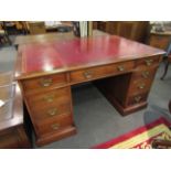 A Georgian style mahogany twin pedestal partners desk with tooled red leather top,