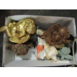 A box of curios including pottery figures, cherub masks,