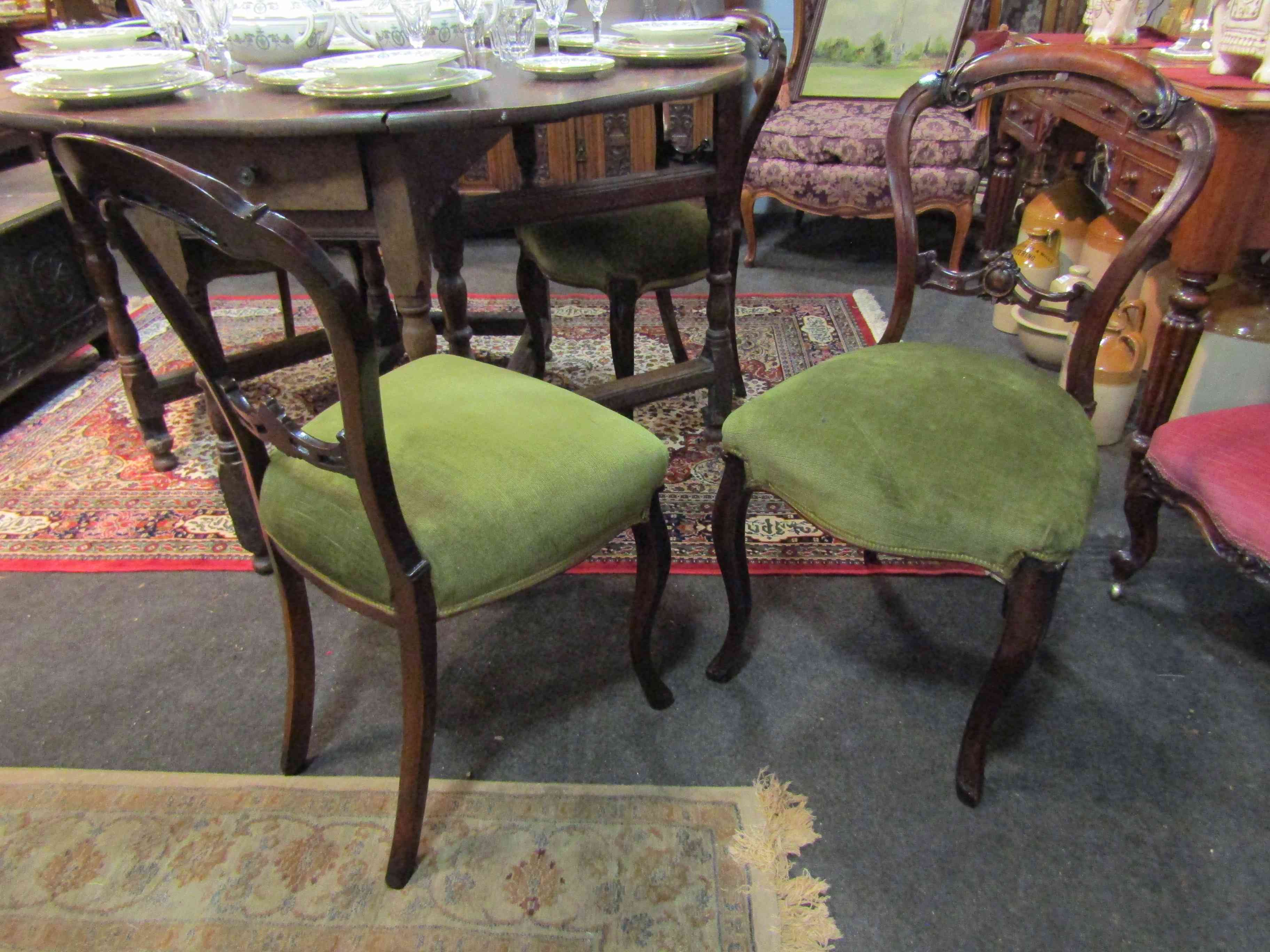 A set of four Victorian walnut balloon back dining chairs, sprung stuffed serpenetine front seats,
