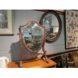 Two mirrors including a shield shape dressing table mahogany example and an oval gilt framed mirror