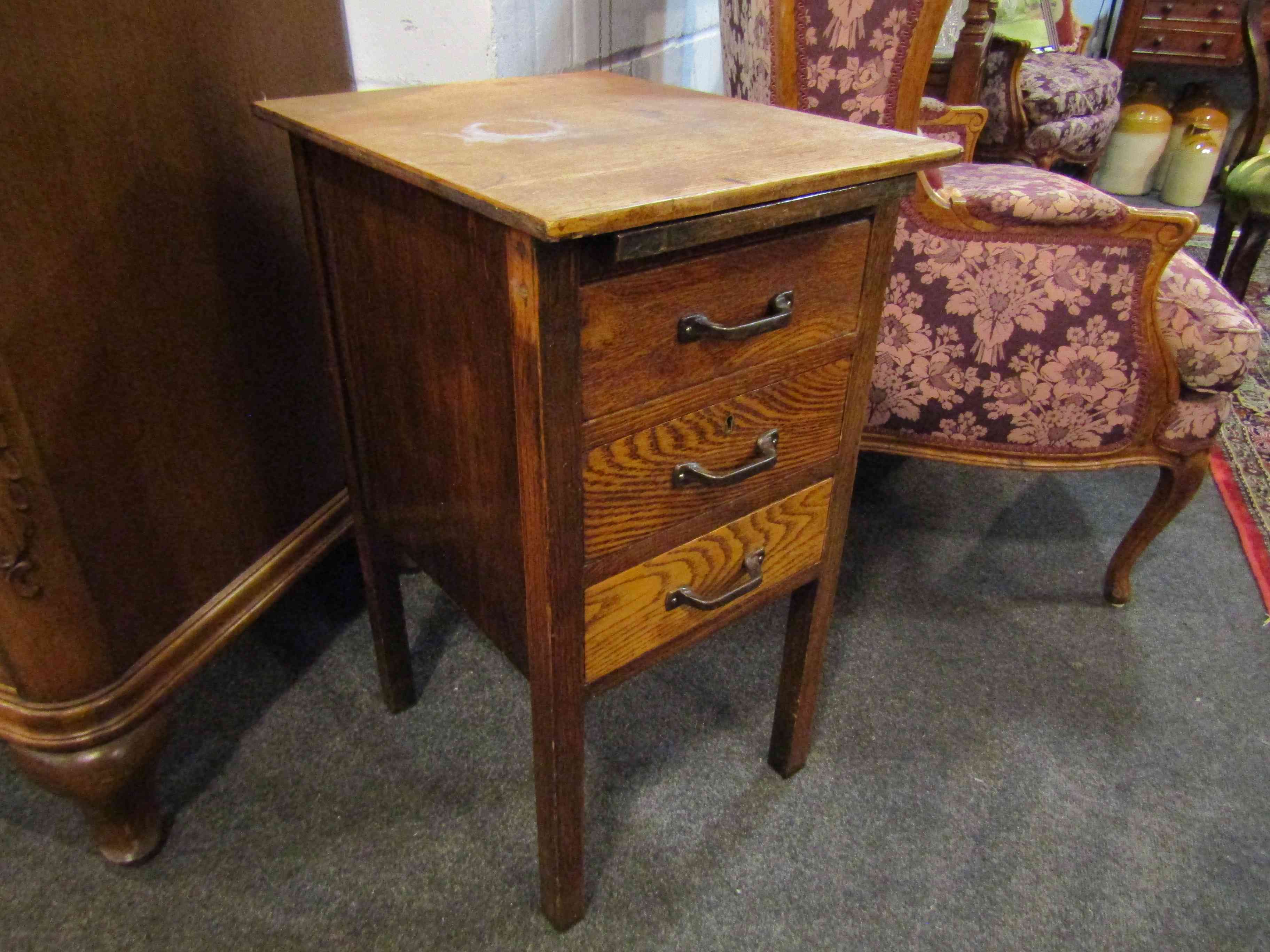 An oak bedside table with pull out tray and three drawers,