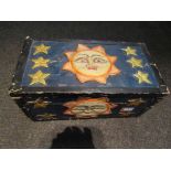 A painted carved wooden box with faces of the moon