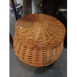 A large modern wicker basket of bulbous form with flat lid,