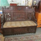 An early carved oak settle with lion head arms.