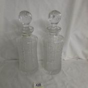 A pair of good quality heavily cut glass decanters in good condition.