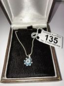 A diamond and blue stone pendant set in 9ct gold with attached chain.