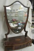 A Victorian mahogany shield shaped toilet mirror on drawer base with shell inlay.