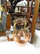 2 copper kettles and a pair of brass candlesticks.