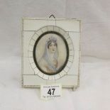 A framed oval miniature portrait of a lady wearing a tiara.