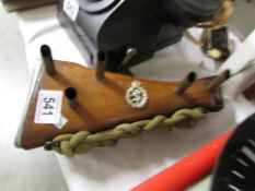 An item of war memorabilia being a rifle stock with regimental badge made in to a stand.