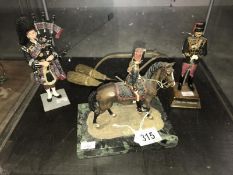 A model of a soldier on horseback, a model of a Scottish piper,