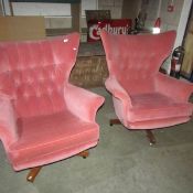 A pair of pink upholstered rocking chairs.
