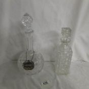 A cut glass decanter with label and one other.